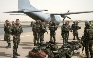 French military personnel stand next to a transport aircraft in Timbuktu, Mali, Thursday, Jan. 31, 2013. Several days after French special forces parachuted in and liberated this storied city, there is a growing sense of freedom. Though in the houses immediately facing the Islamic tribunal, many of the 8- and 9-year-old girls are still wearing the head covering. (AP Photo/Harouna Traore)